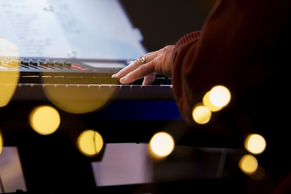 a person playing a piano with a lot of lights around it