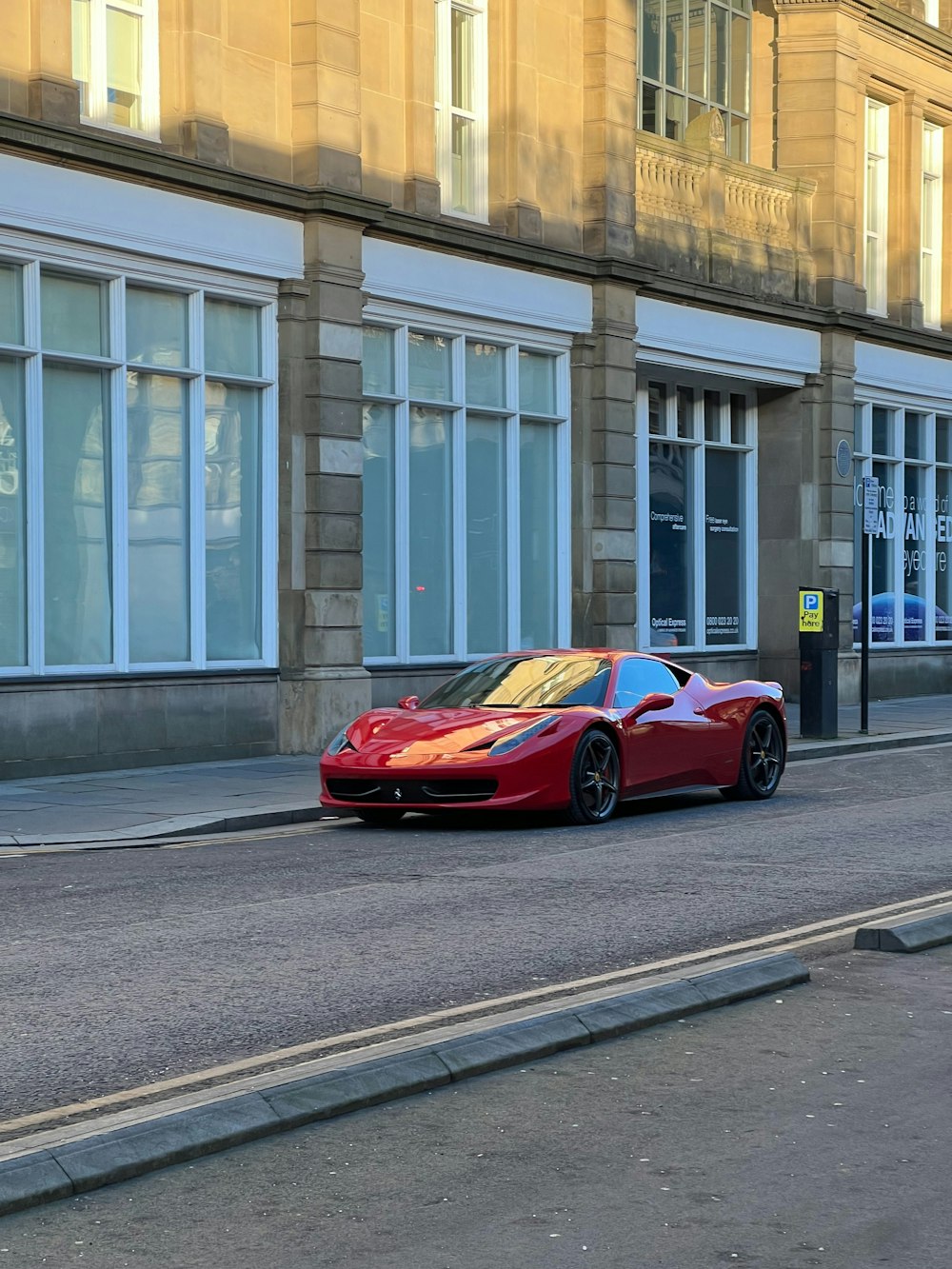 a red sports car parked on the side of the road