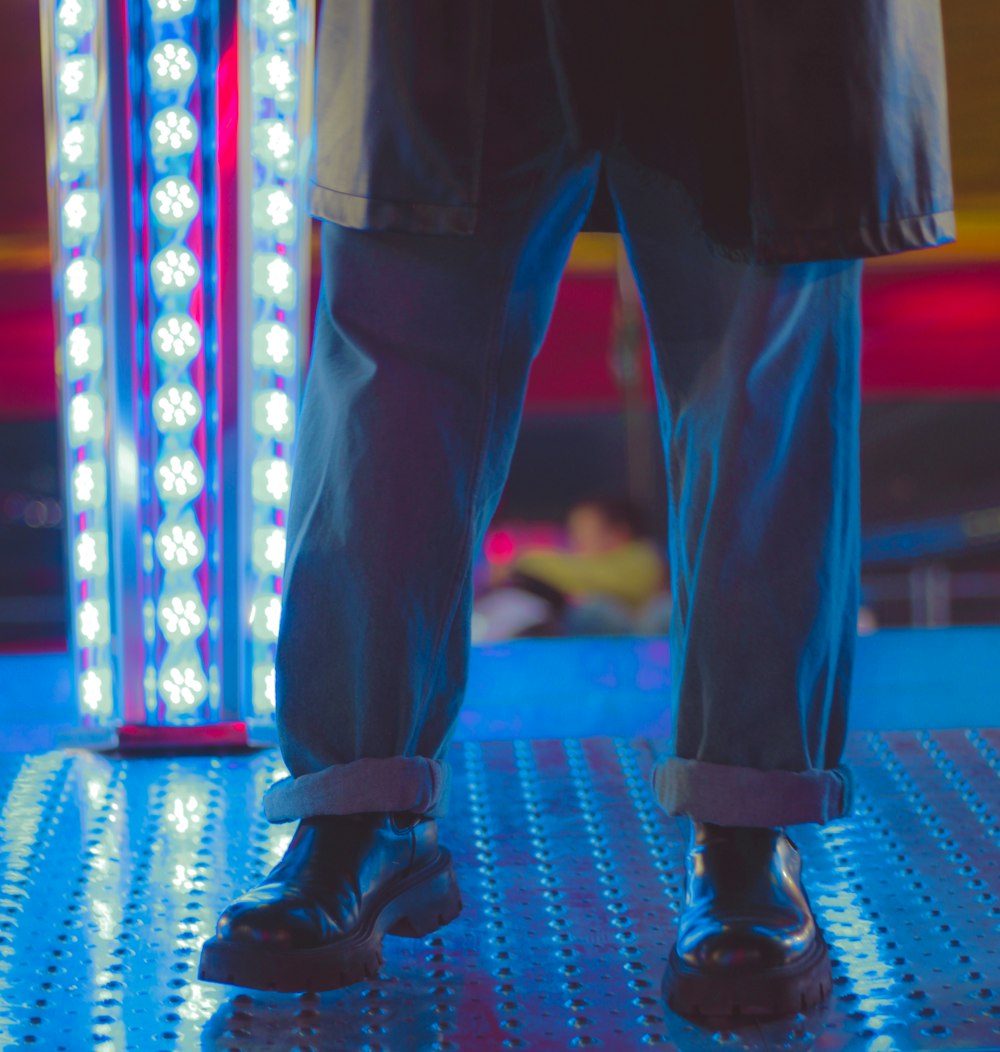 a close up of a person's legs wearing black shoes