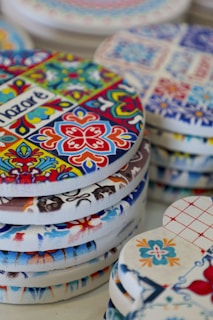 a pile of colorful tile ceramic coasters sitting on top of a table