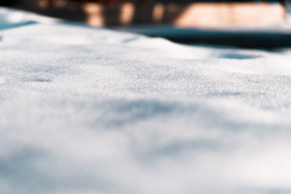 a close up of a snow covered surface with a building in the background