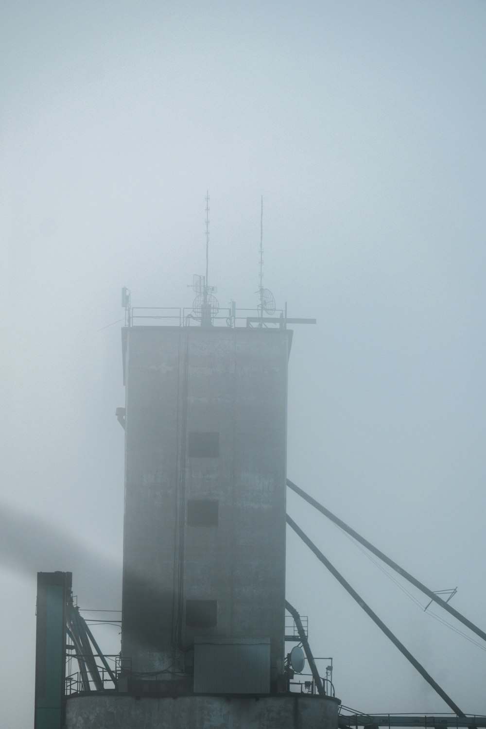 a tall building sitting on top of a foggy hillside