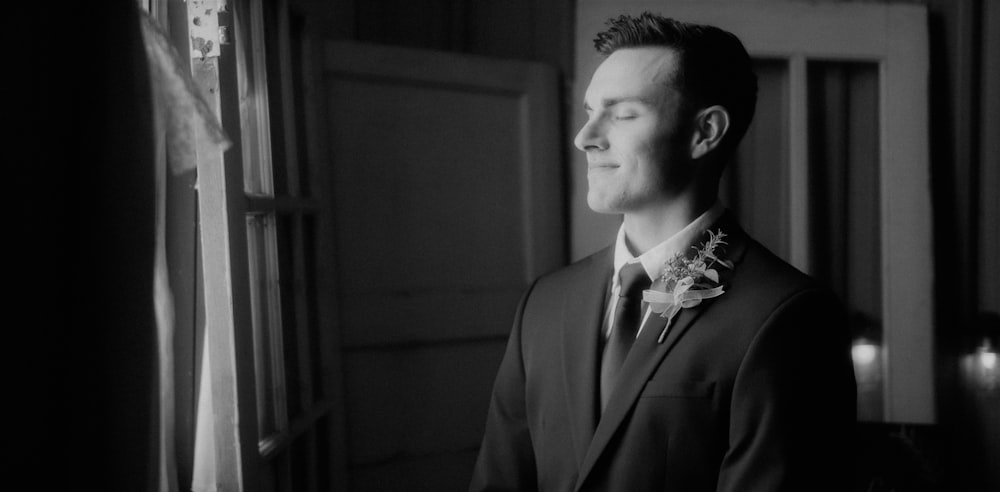 a man in a suit looking out a window