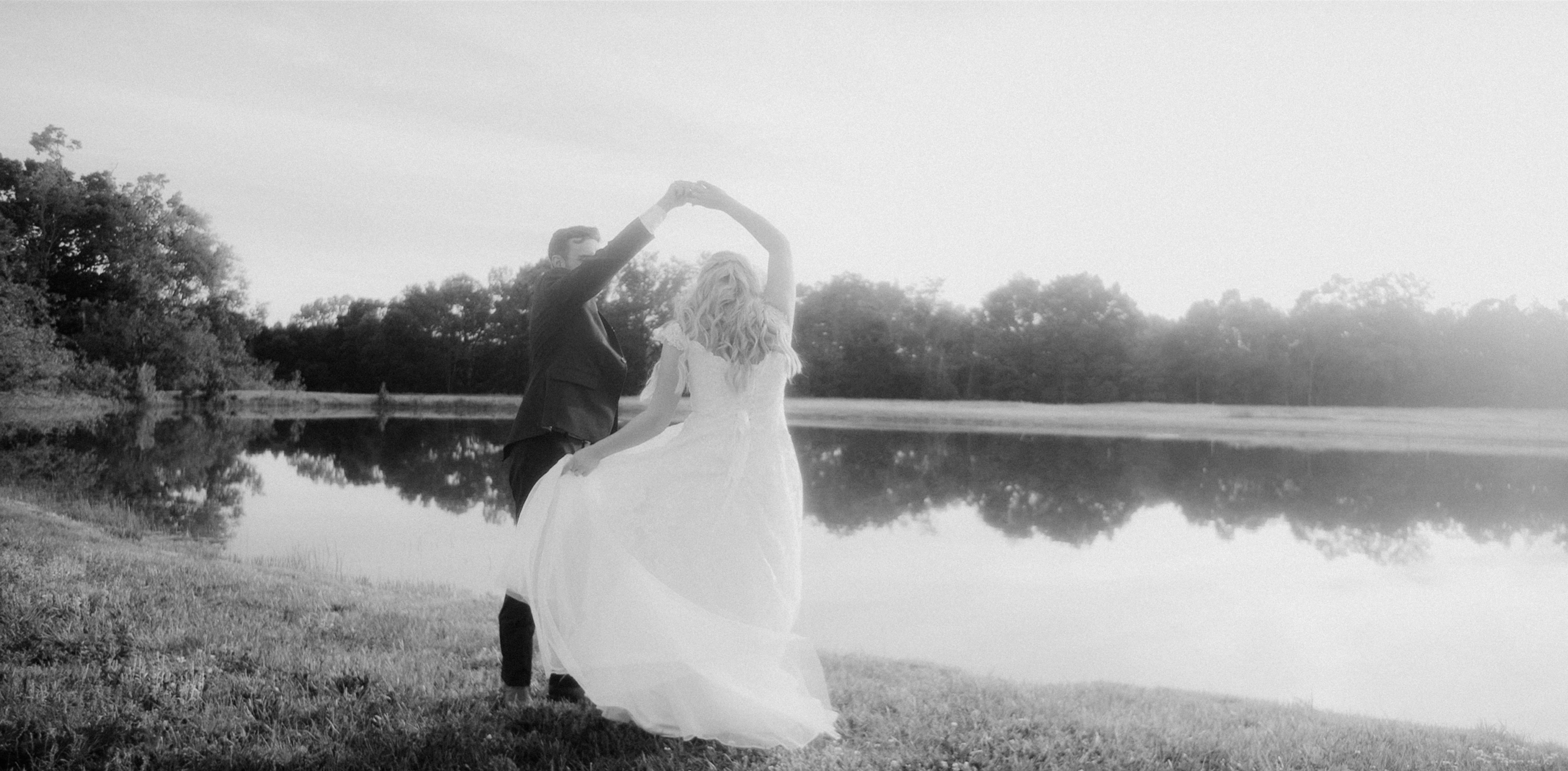 a bride and groom dancing in front of a lake, This is a still frame from a 550Park Wedding Film. 550Park is A Luxury Wedding Film Studio based out of New York City. Traveling Worldwide for our Couples. Films by Brent Szklaruk. Wedding packages begin at $1,500.