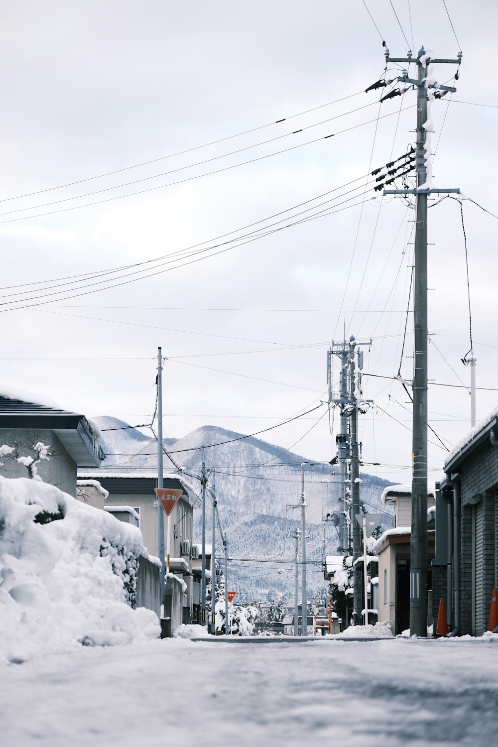 eine Straße mit Schnee auf dem Boden und Stromleitungen im Hintergrund