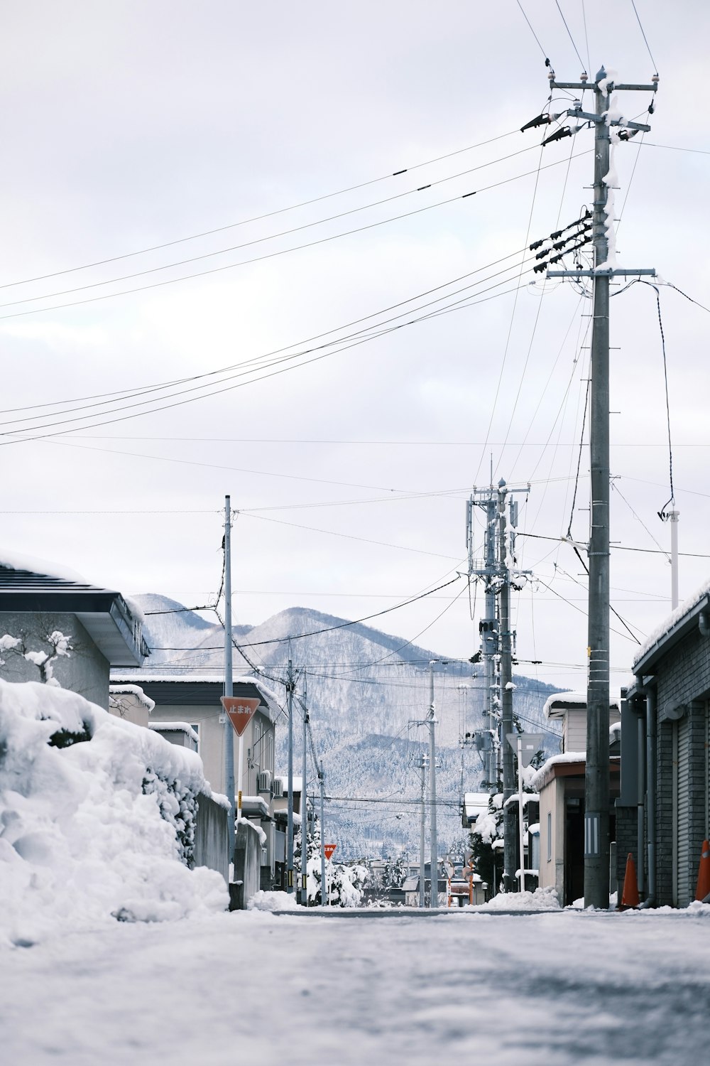 a street with snow on the ground and power lines in the background