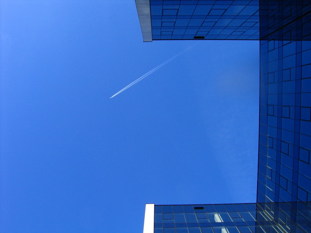 a plane is flying in the sky between two buildings