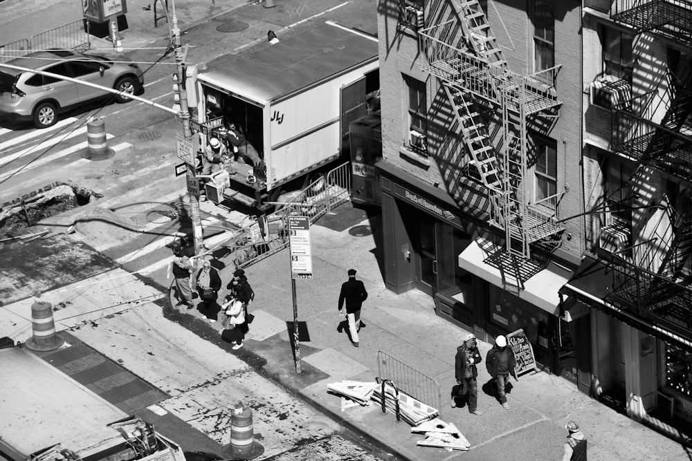 a black and white photo of people walking down a street