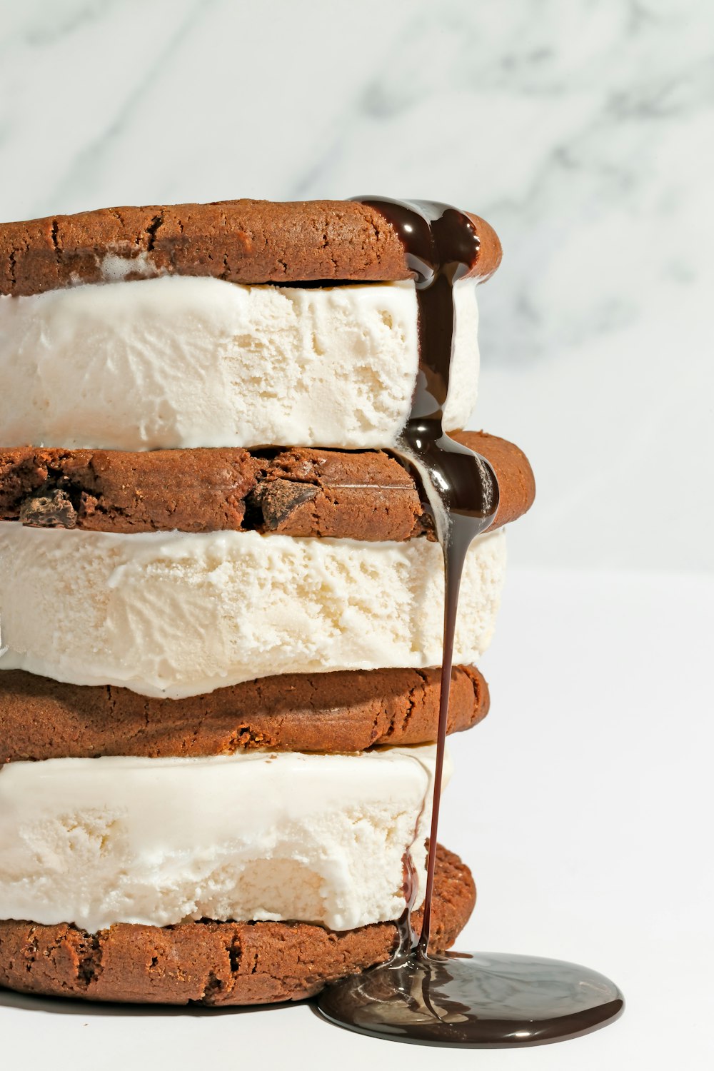 a stack of ice cream sandwiches with chocolate sauce drizzled on top