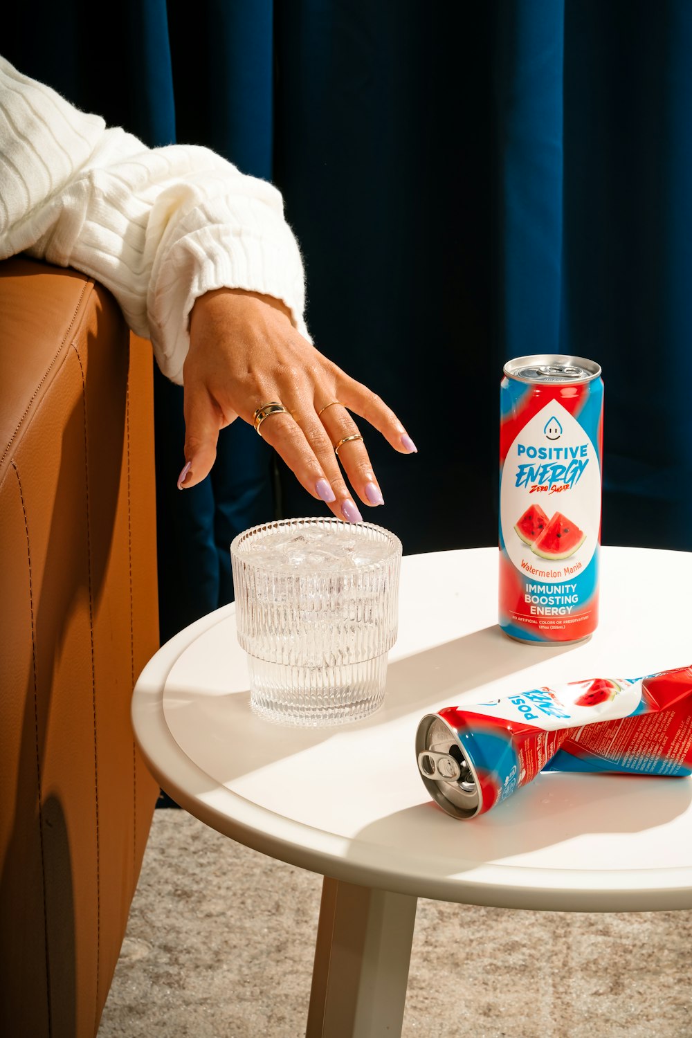 a woman's hand on a table next to a can of watermelon
