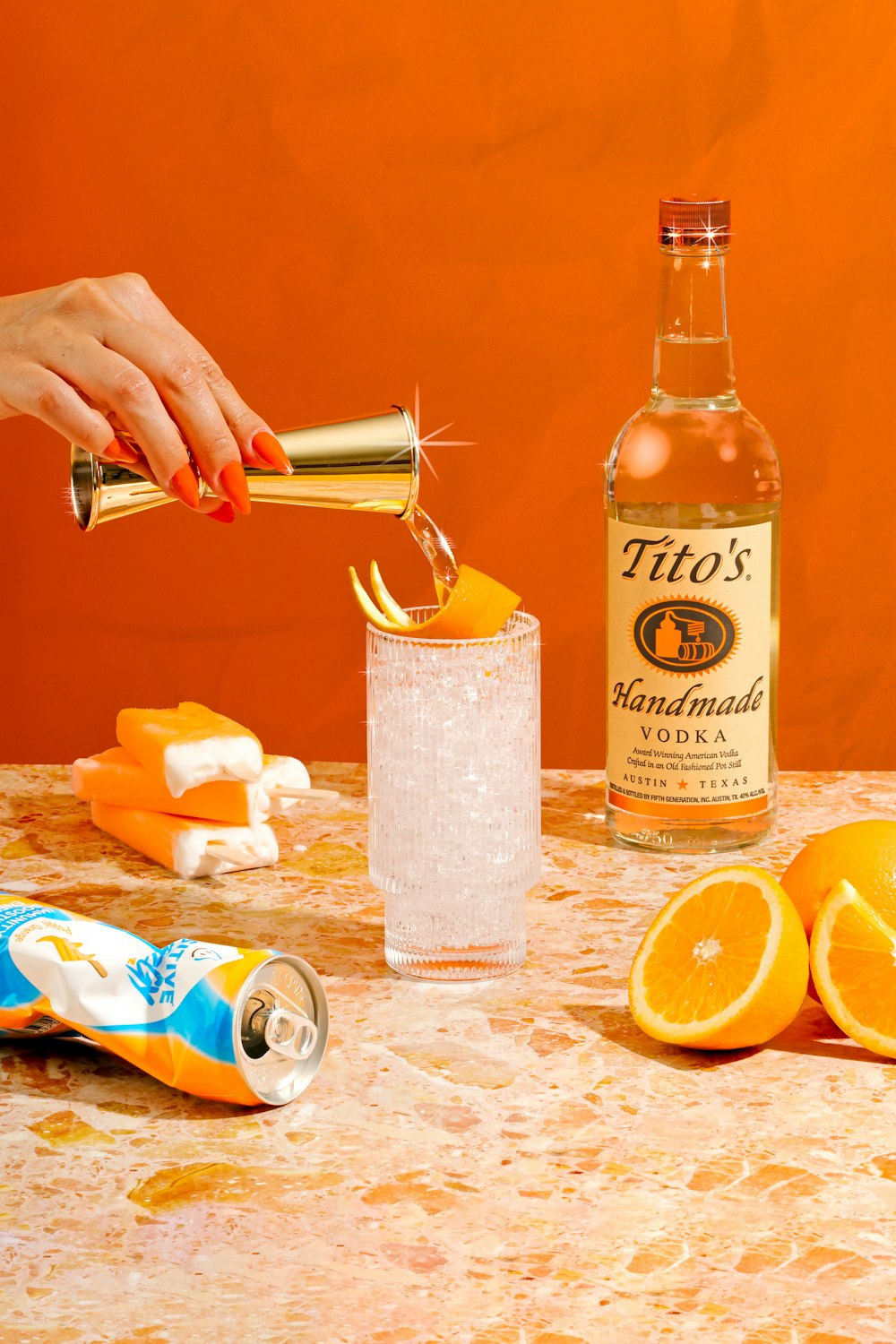 a person pouring a drink into a glass