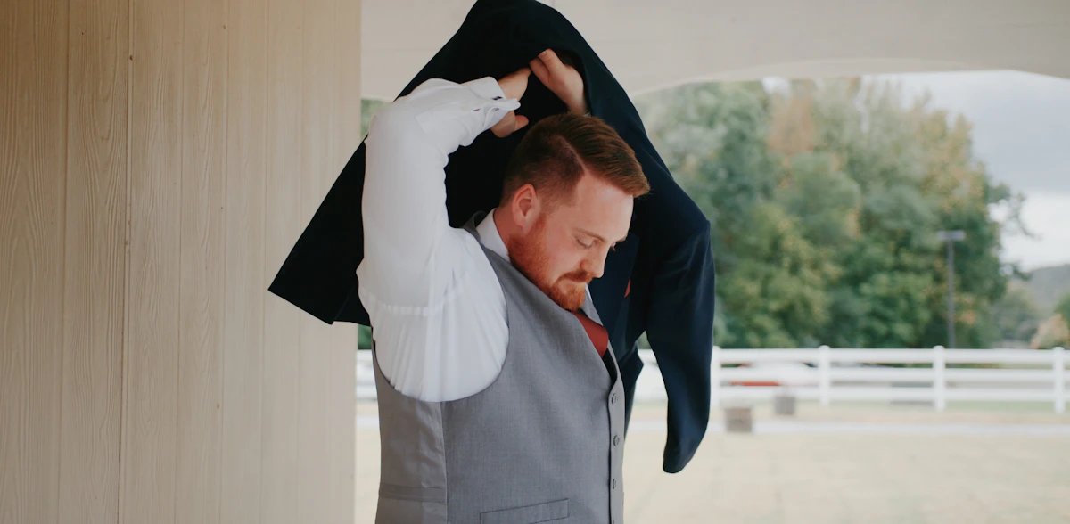 a man that is standing up with a suit on