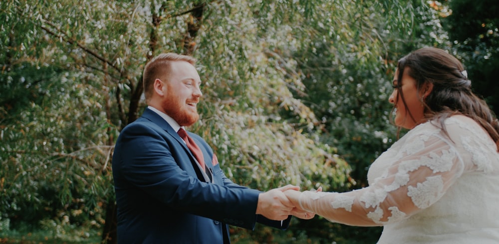 a bride and groom holding hands and smiling