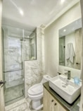a bathroom with a toilet, sink, and shower