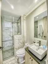 a bathroom with a toilet, sink, and shower