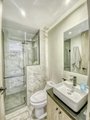 a bathroom with a toilet, sink, and shower