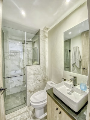 a bathroom with a toilet, sink, and shower
