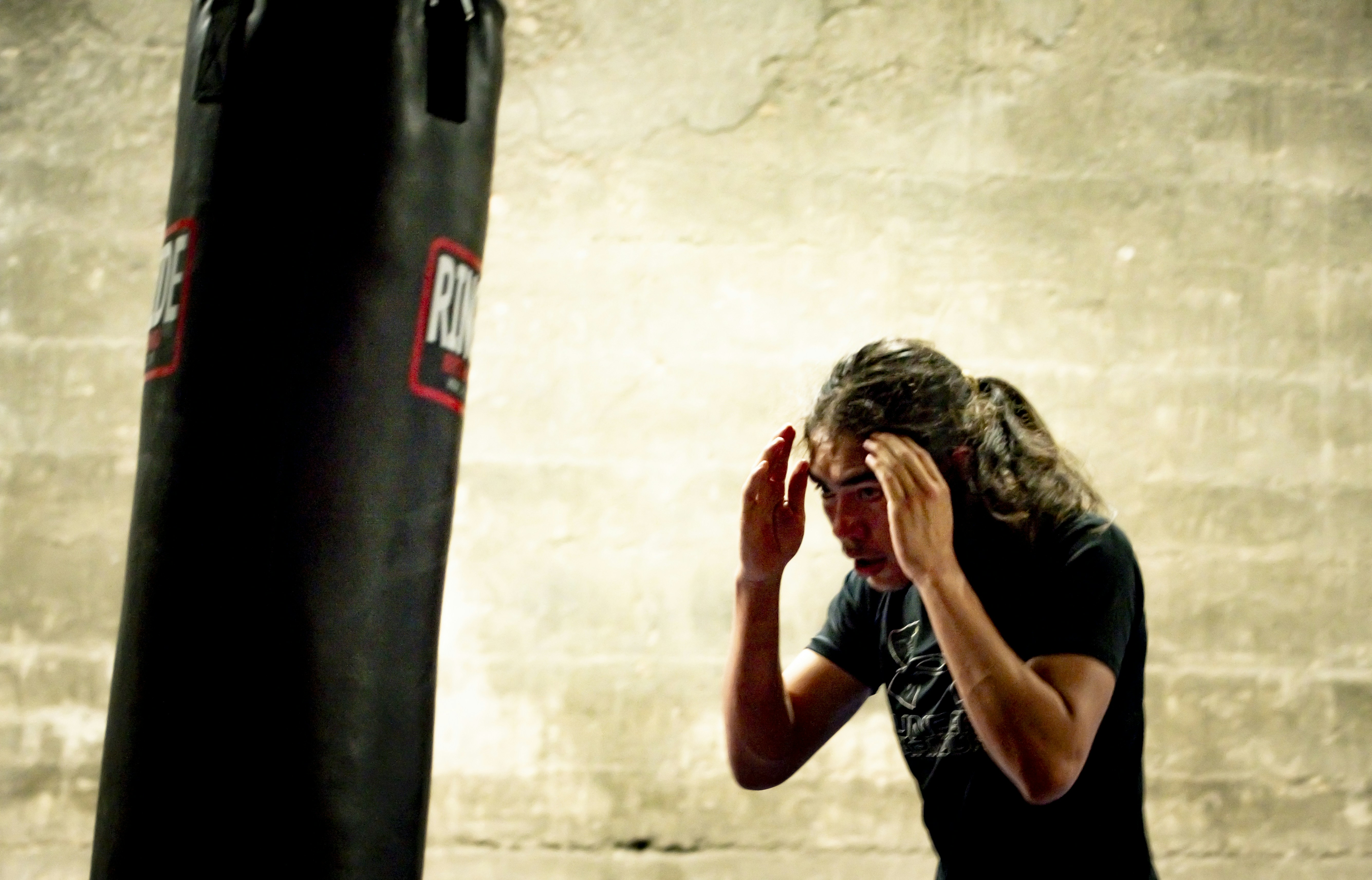 a man standing next to a punching bag
