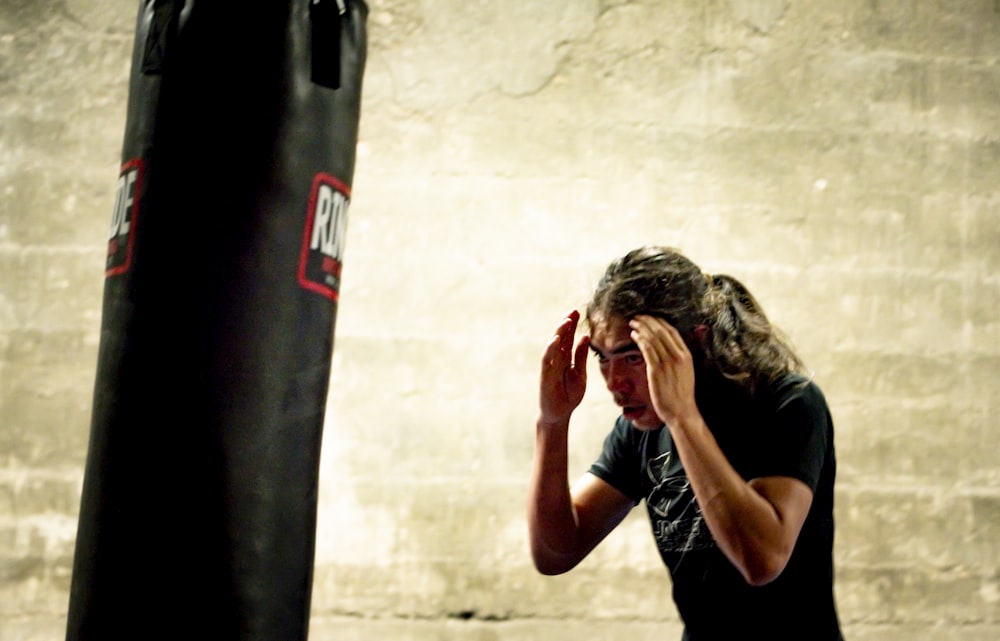 a man standing next to a punching bag