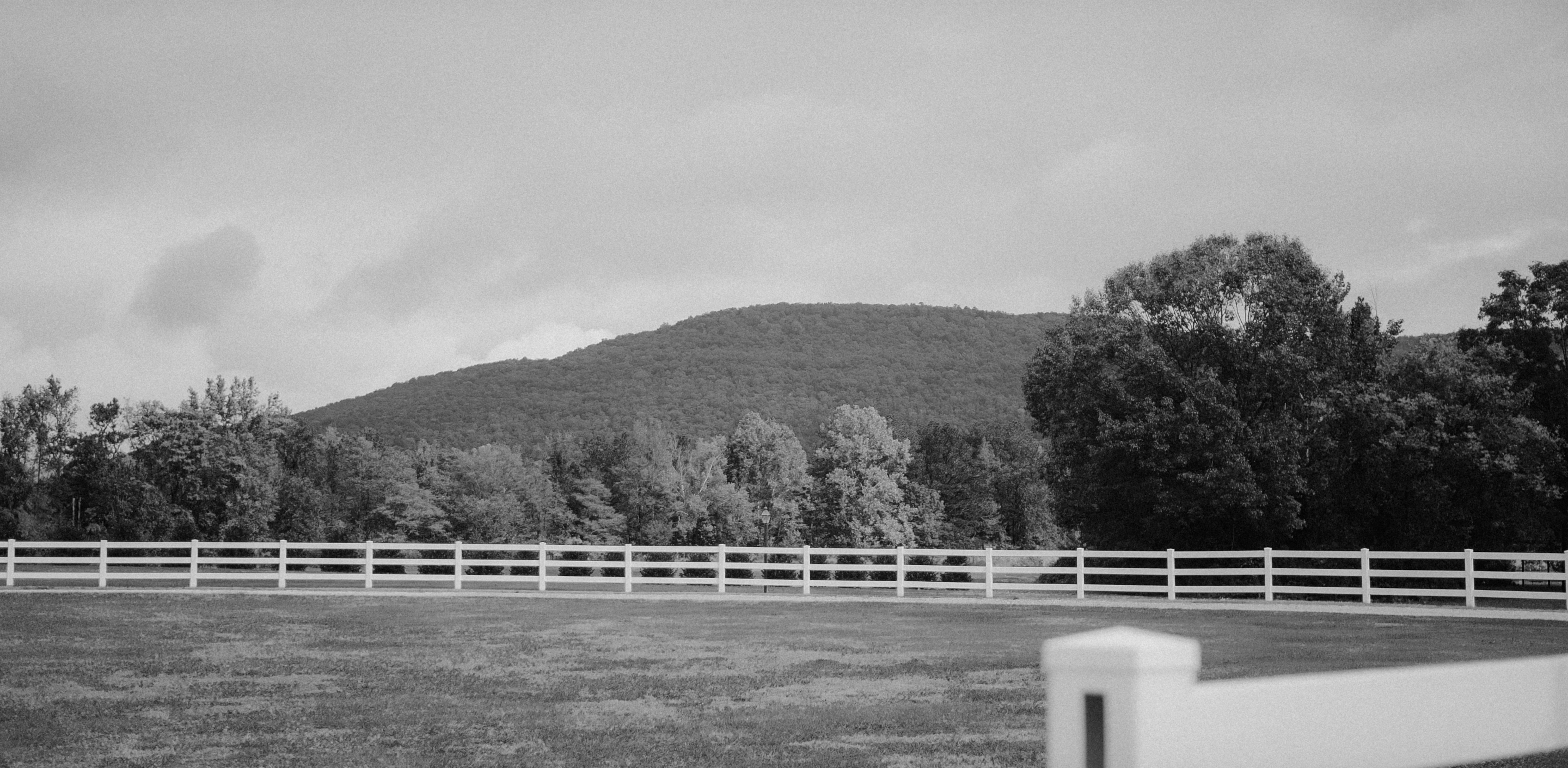 a black and white photo of a fenced in field