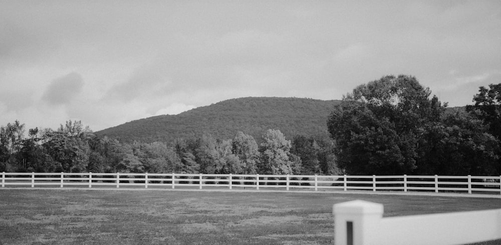 a black and white photo of a fenced in field