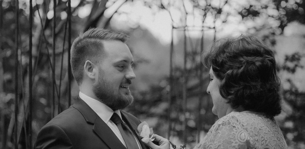 a man in a suit and tie standing next to a woman