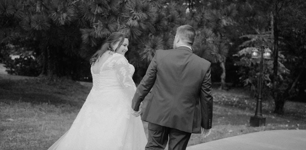 a bride and groom walking down a sidewalk