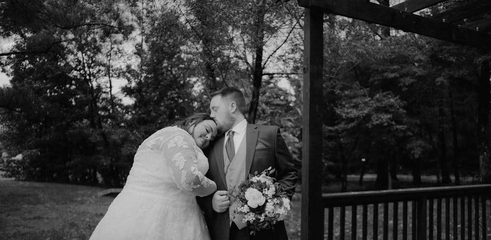 a bride and groom kissing in front of a gazebo