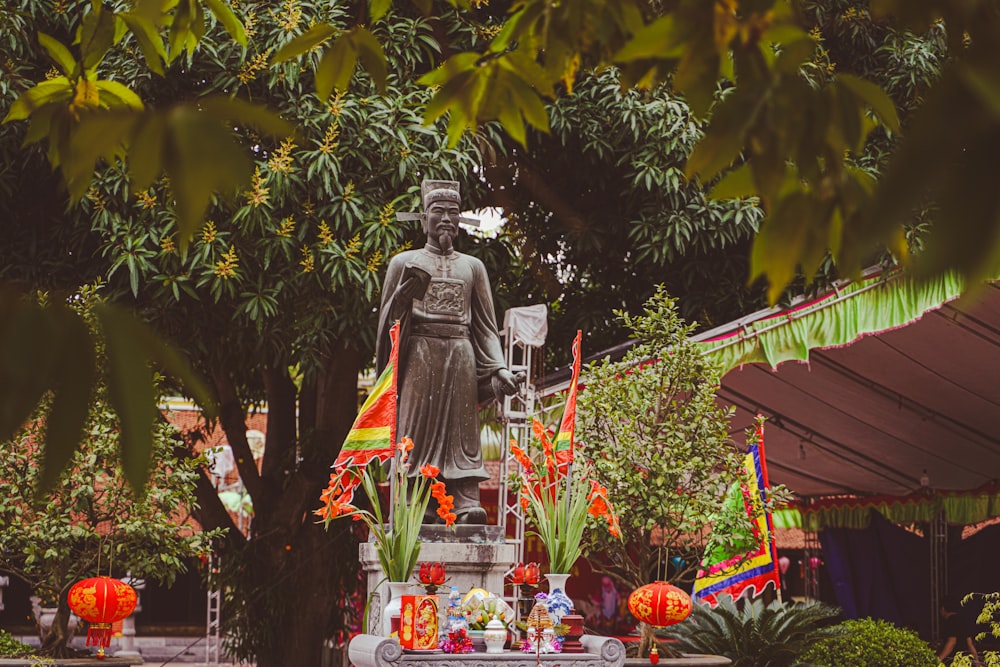 a statue of a man holding a sword in a garden