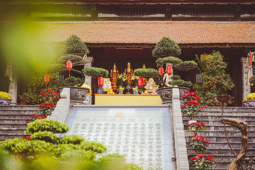 a statue of buddhas in a temple surrounded by flowers