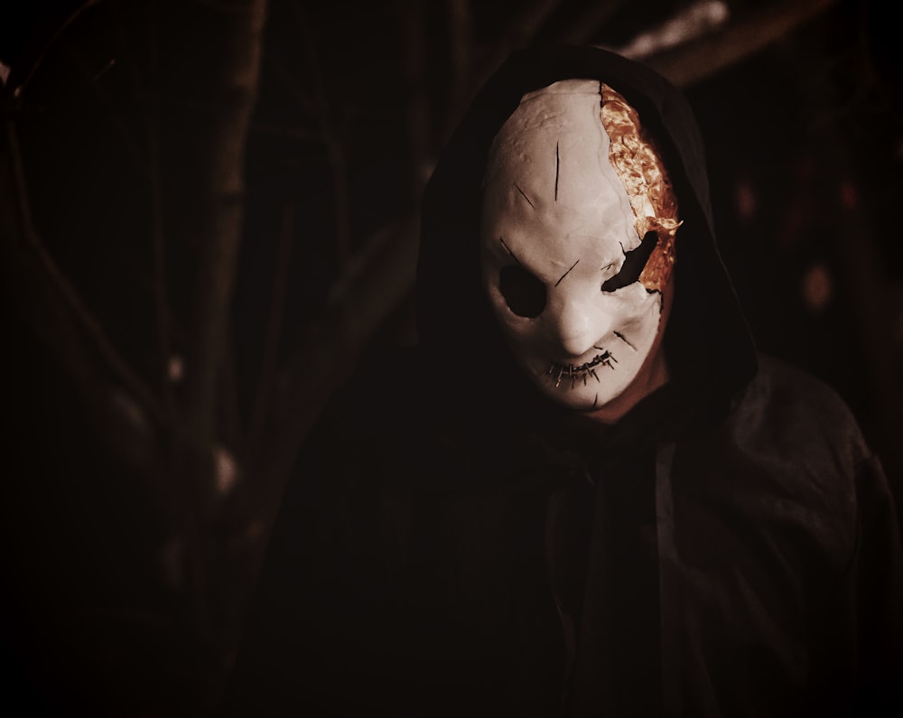 a person wearing a creepy mask and a hood