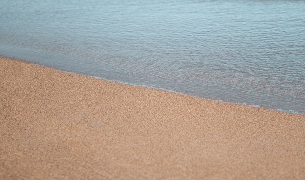 a sandy beach next to a body of water