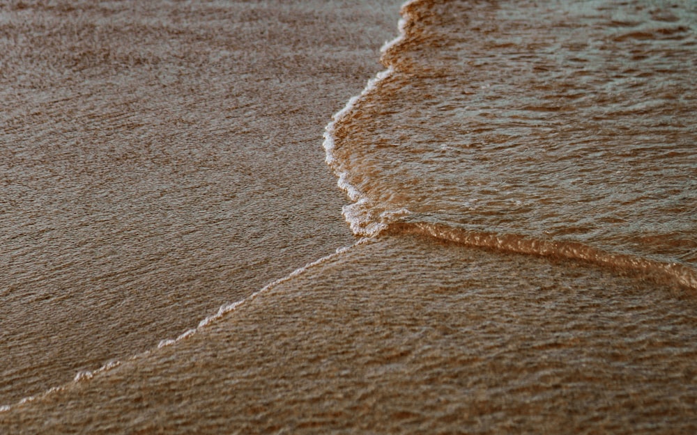 a wave rolls in on the sand of a beach