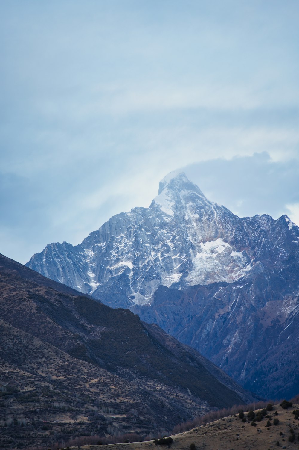 a mountain range with a snow covered peak in the distance