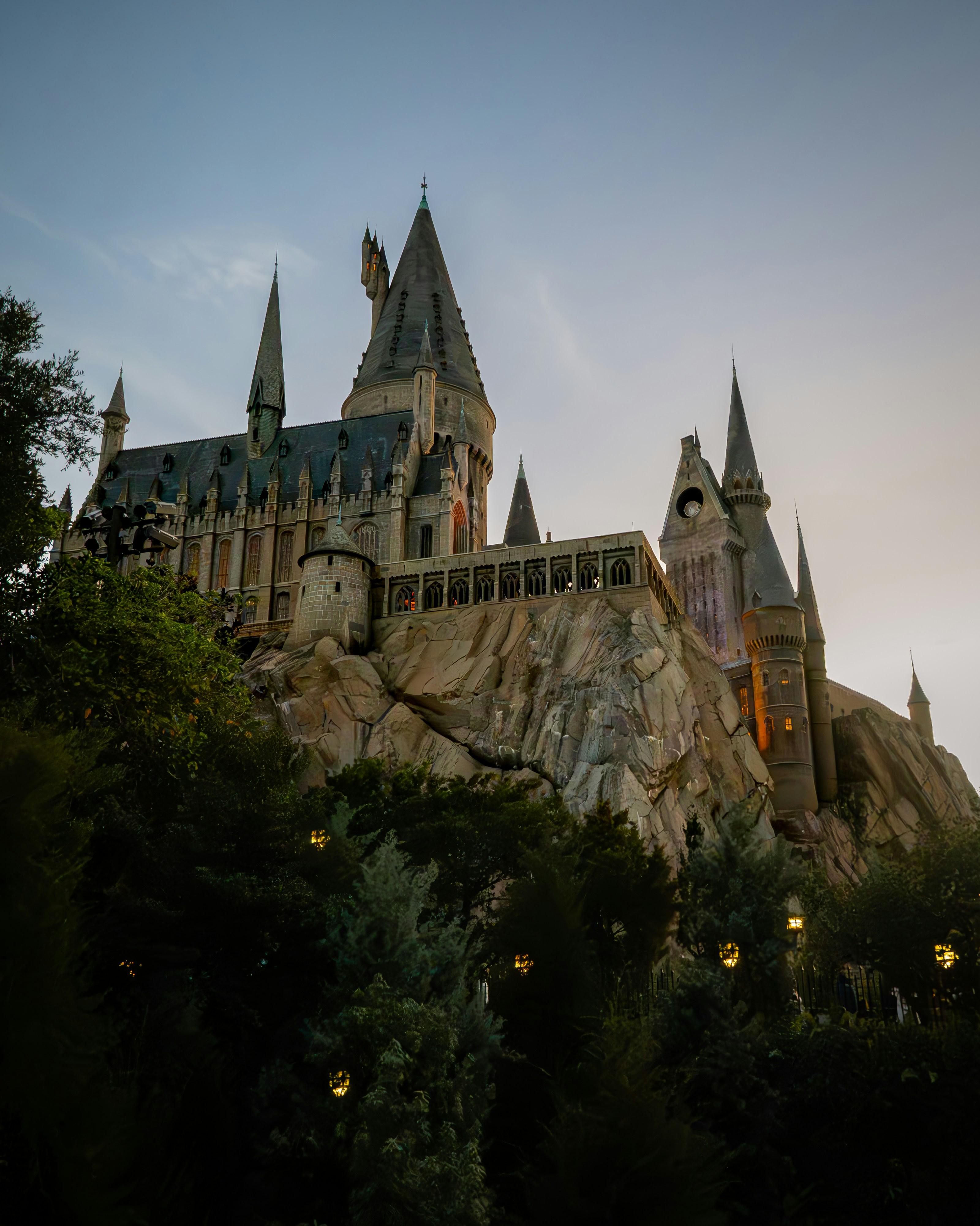 Arquitetura do Wizarding World em estilo de castelo no Universal Studios Florida, Orlando, Estados Unidos, emoldurada contra um céu azul para uma vista dramática de uma atração temática.