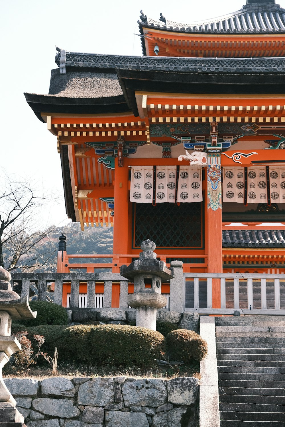 a tall orange building sitting next to a stone wall