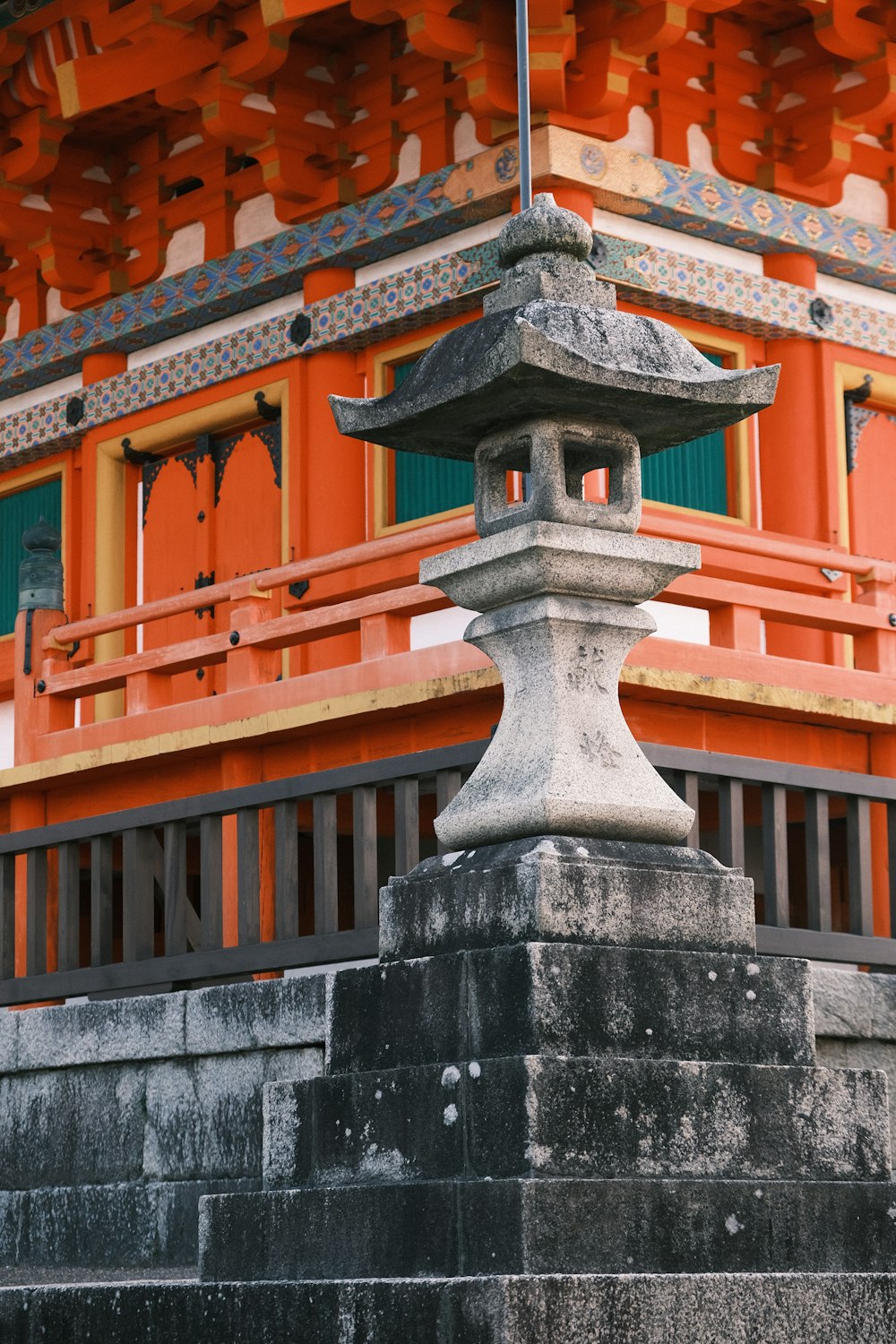 a stone lantern in front of an orange building