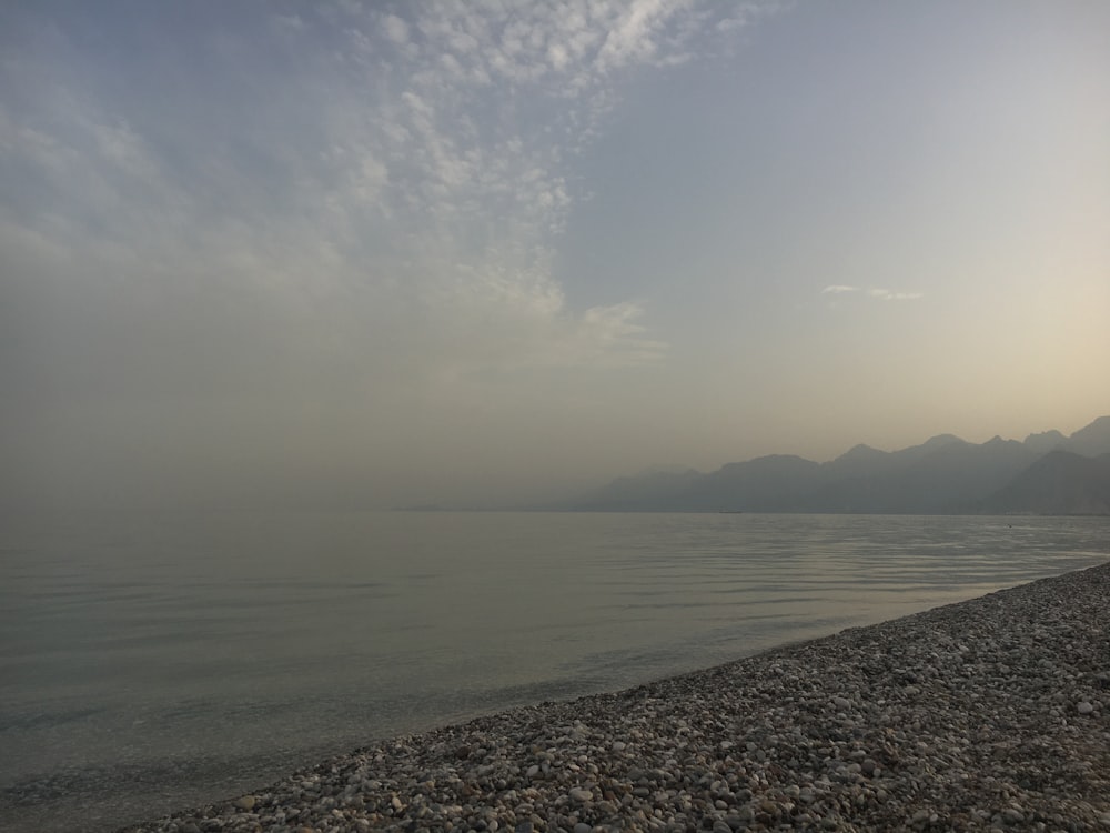 a body of water with mountains in the background