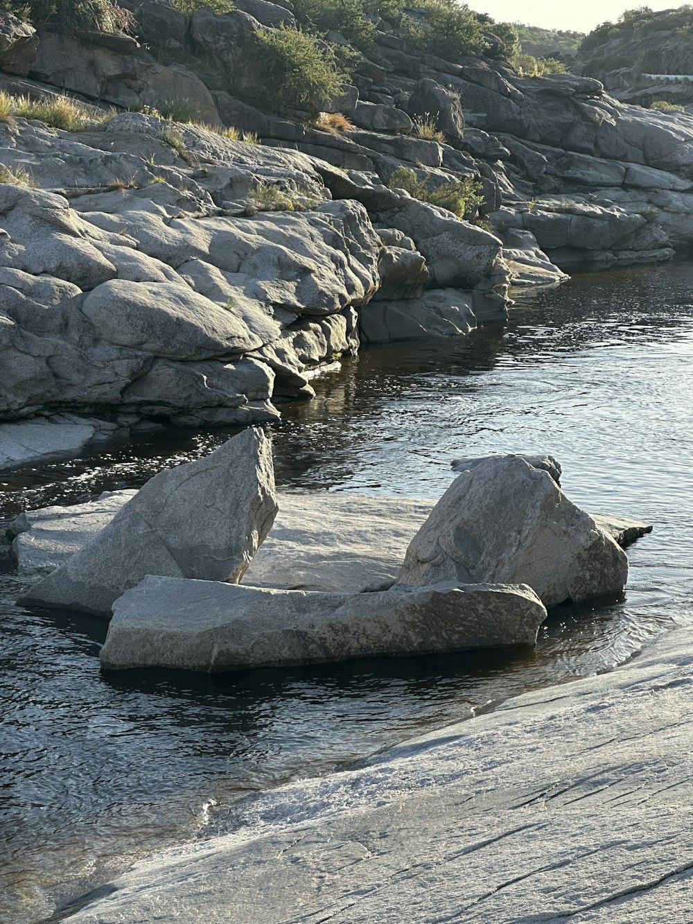 a large rock sitting in the middle of a river