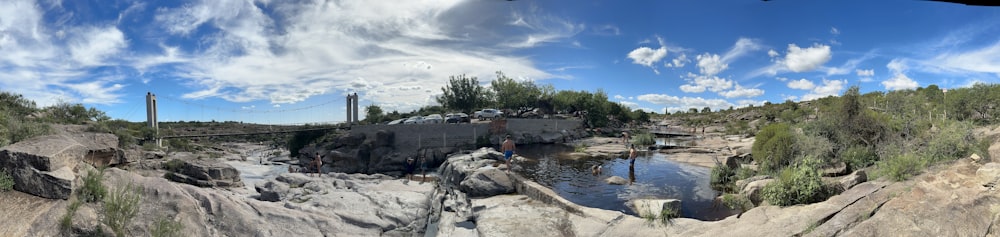 a panorama of a river with a bridge in the background