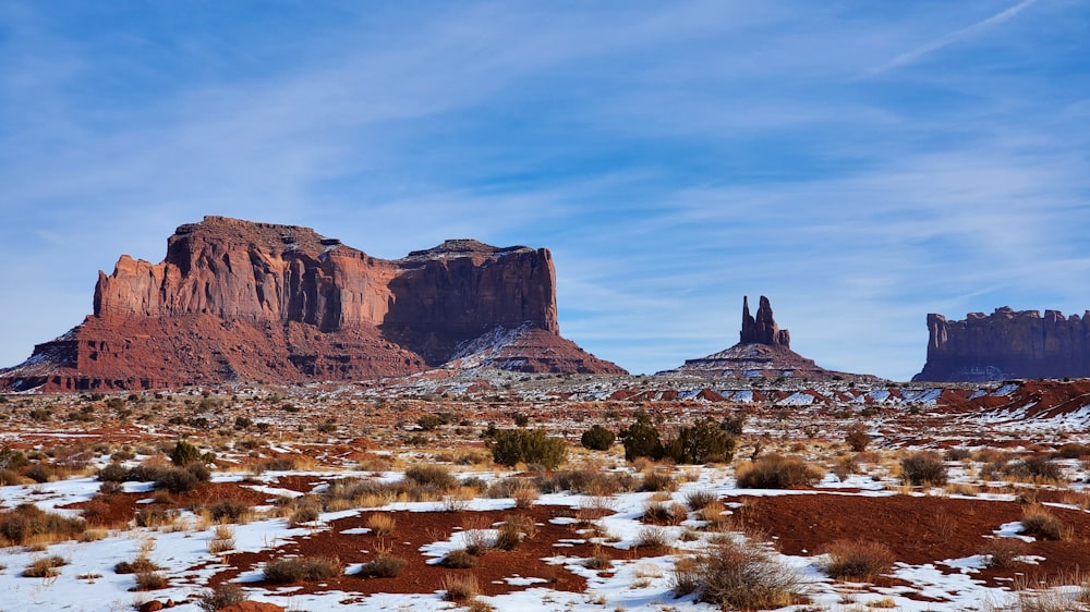 a snowy landscape with mountains in the background