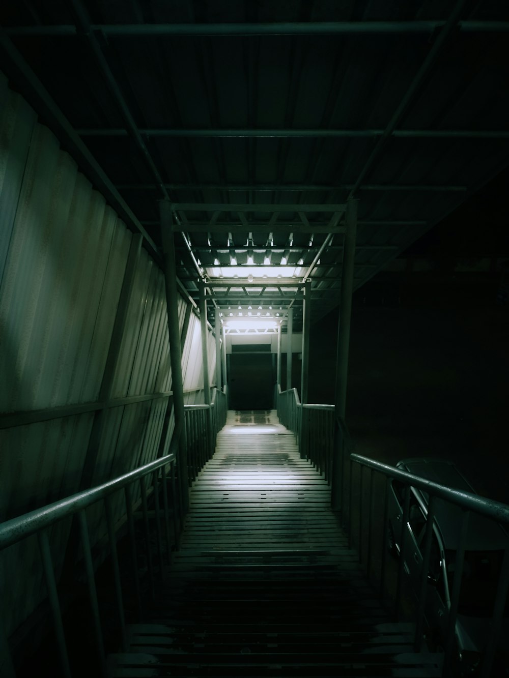 a dark hallway with stairs leading up to the exit