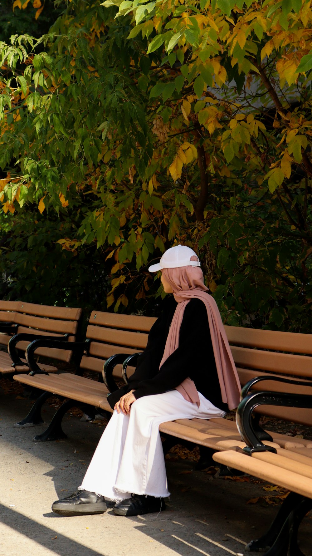 a woman sitting on a bench in a park