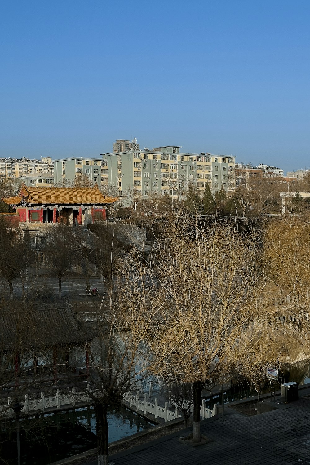 a view of a city with buildings and trees in the foreground