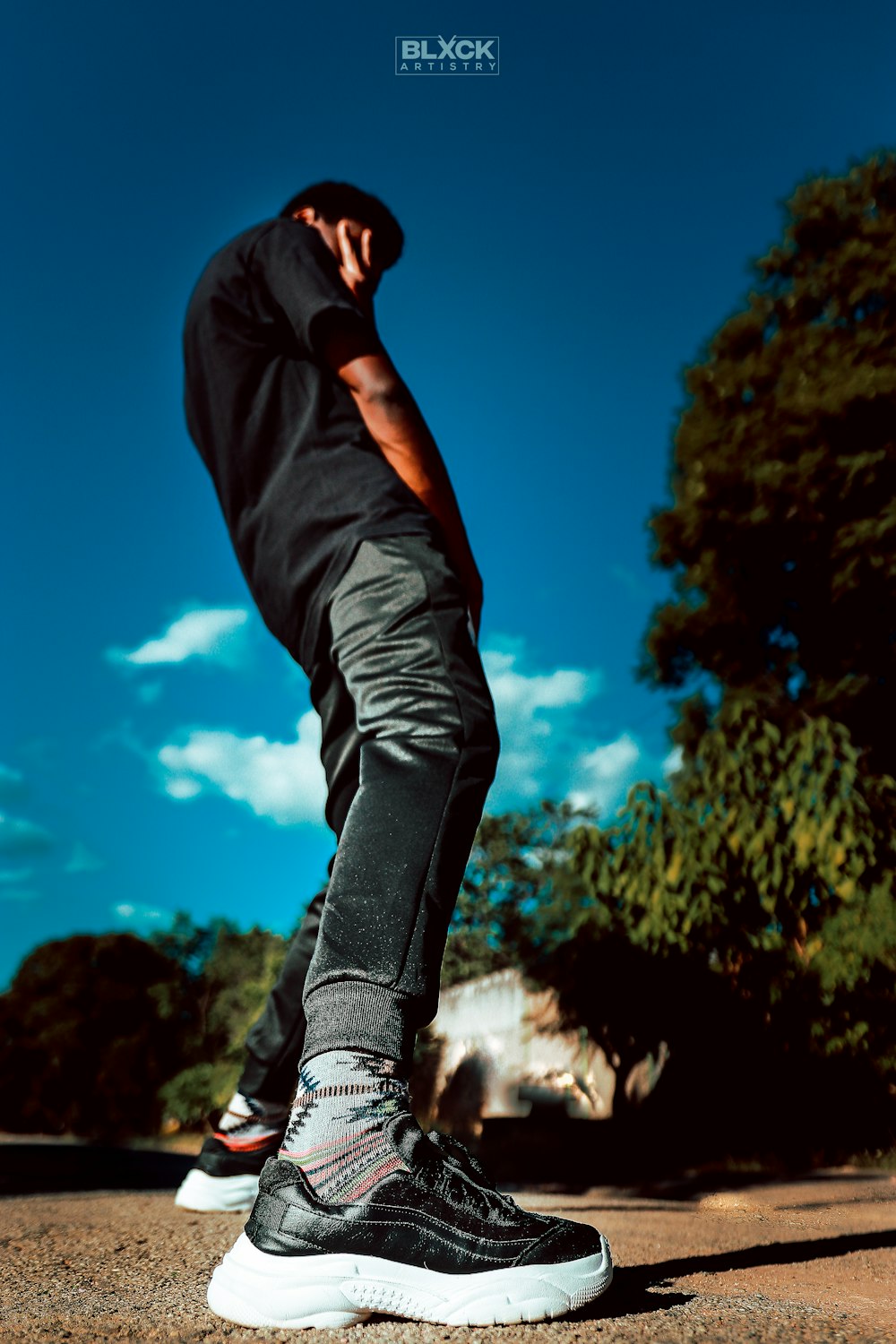 a man standing on top of a skateboard on a street