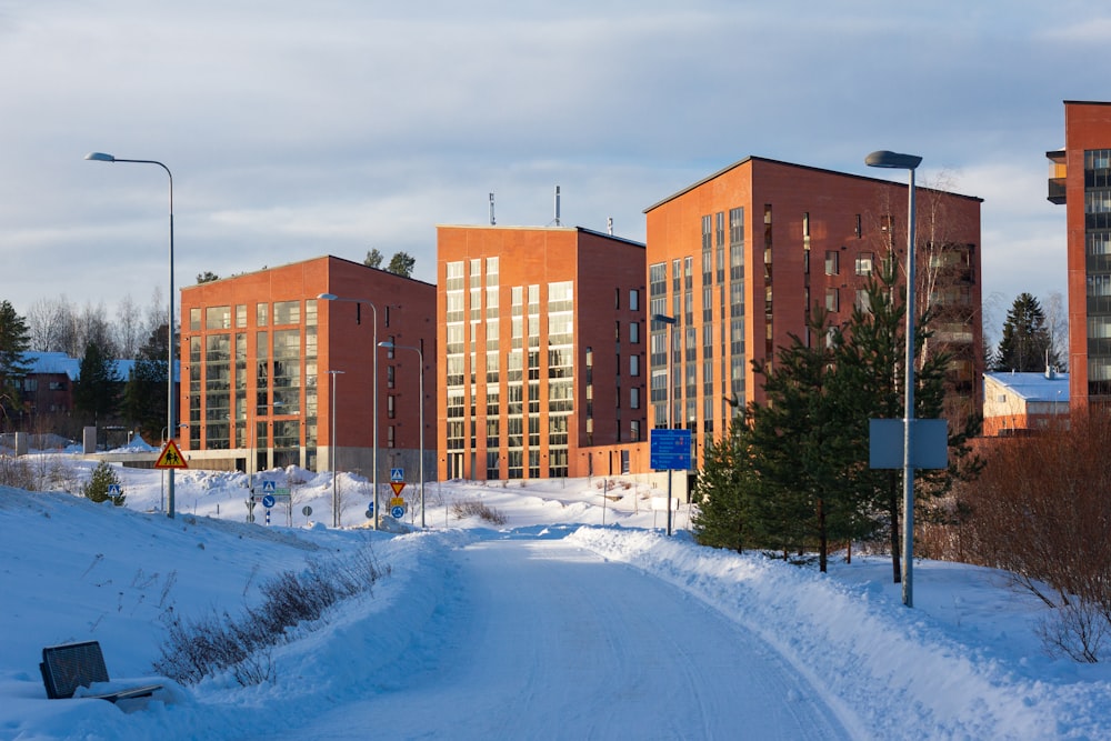 a street with snow on the ground and buildings in the background