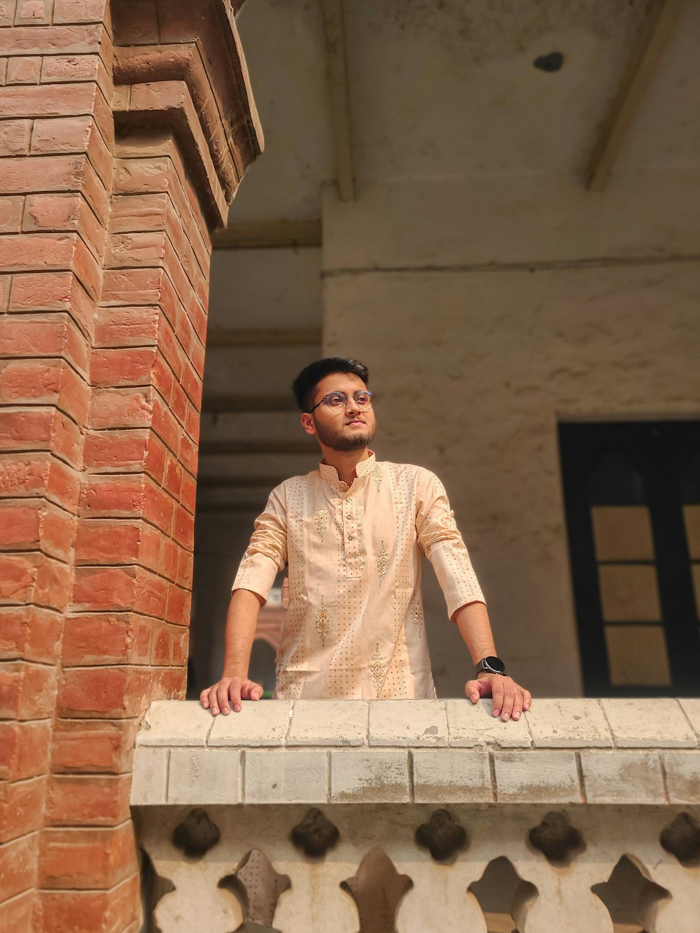 a man standing on a balcony with his hands on his hips