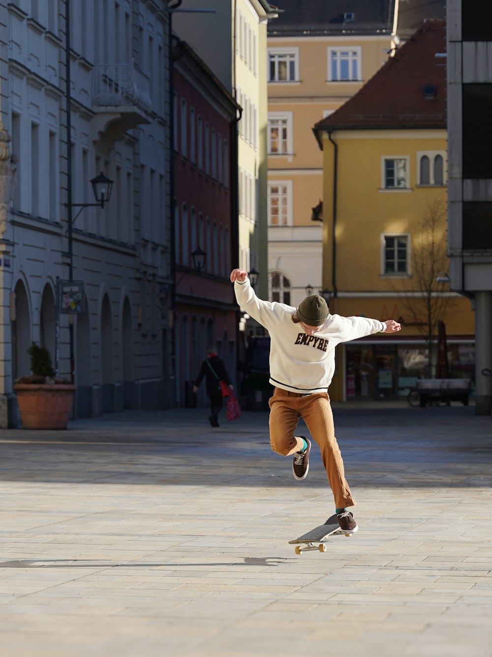 a man riding a skateboard down a street next to tall buildings