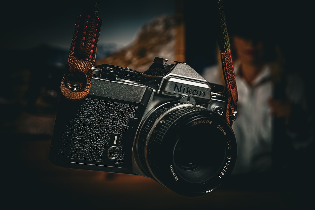 a camera hanging from a rope with a man in the background,