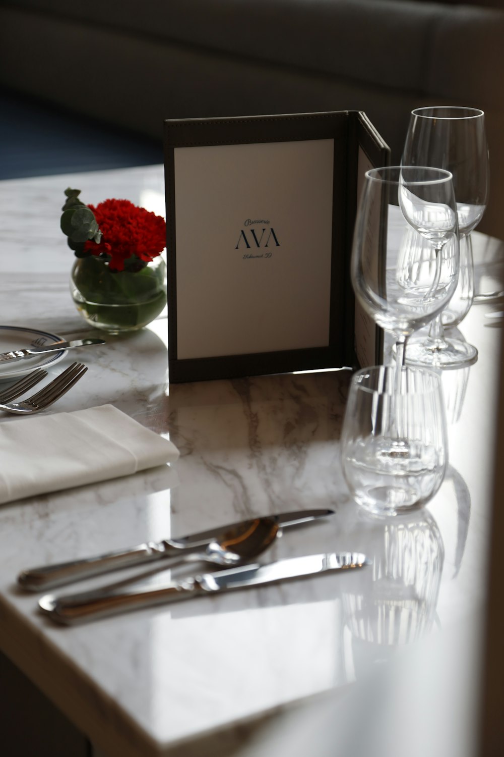 a table topped with wine glasses and silverware